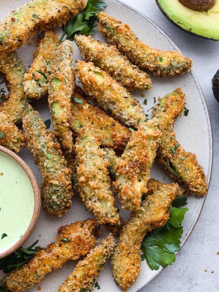 Closeup of fried avocado slices on a gray plate.