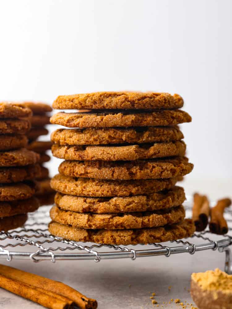 Gingersnap cookies stacked on top of each other on a wire rack.