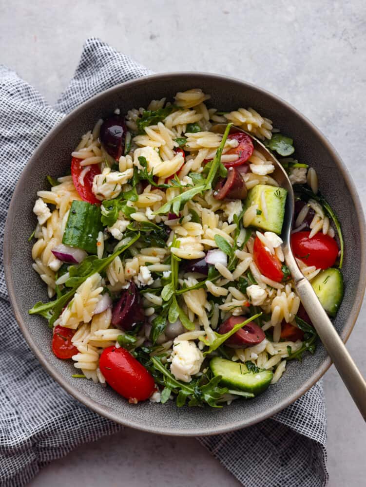 The top view of a serving size bowl filled with salad and a spoon. 