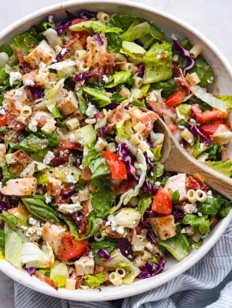 The top view of a Portillo's chopped salad with a wooden spoon. 