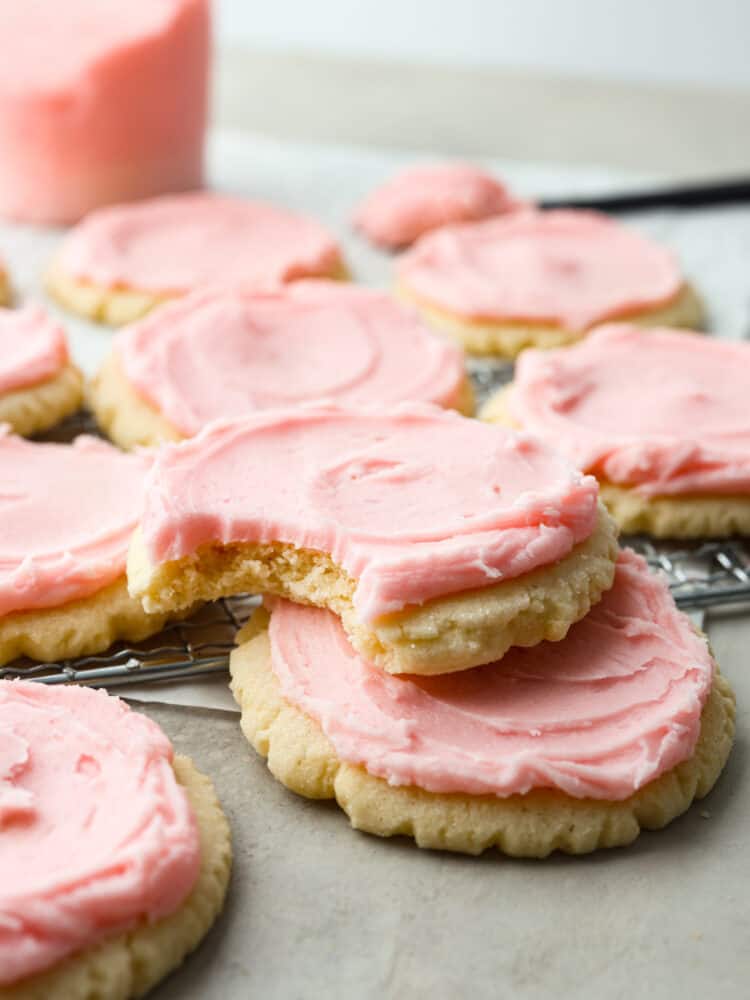 A stack of sugar cookies with a bite taken out of the top one. 