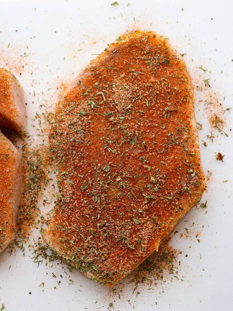 A close up photo of a fish fillet seasoned with the fish seasoning.