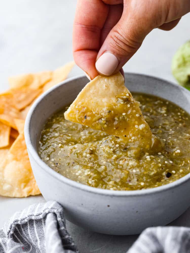 Dipping a tortilla chip into tomatillo salsa.