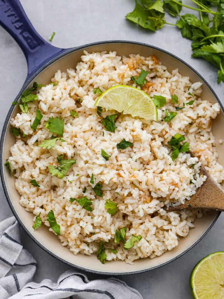 A pan of cilantro lime rice with a lime wedge on top. 