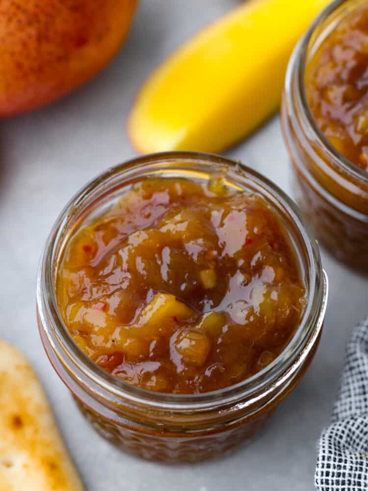 The topview of a glass jar filled with tomato chutney.