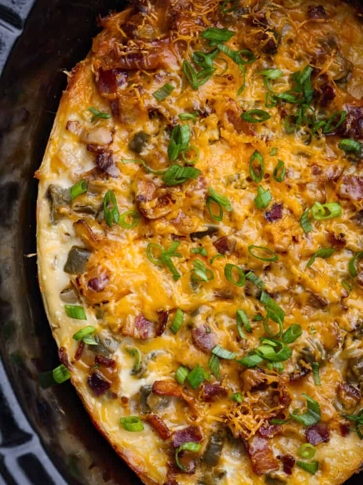 A close up of cooked overnight breakfast casserole in the crockpot. 