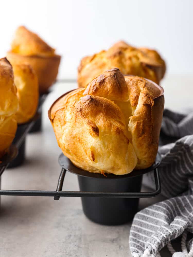 Closeup of a baked popover roll, still in the pan.