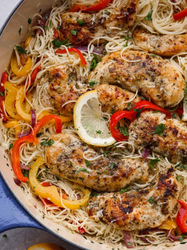 Closeup of chicken scampi in a white and blue skillet.