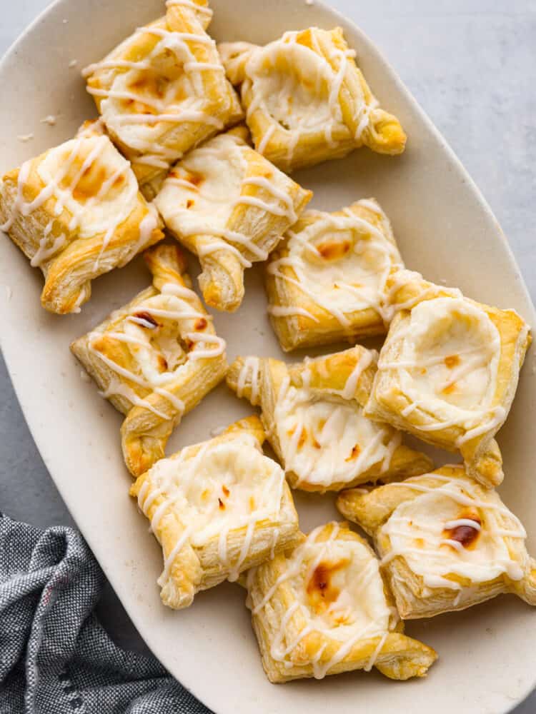 Multiple cheese danishes served on a white plate.