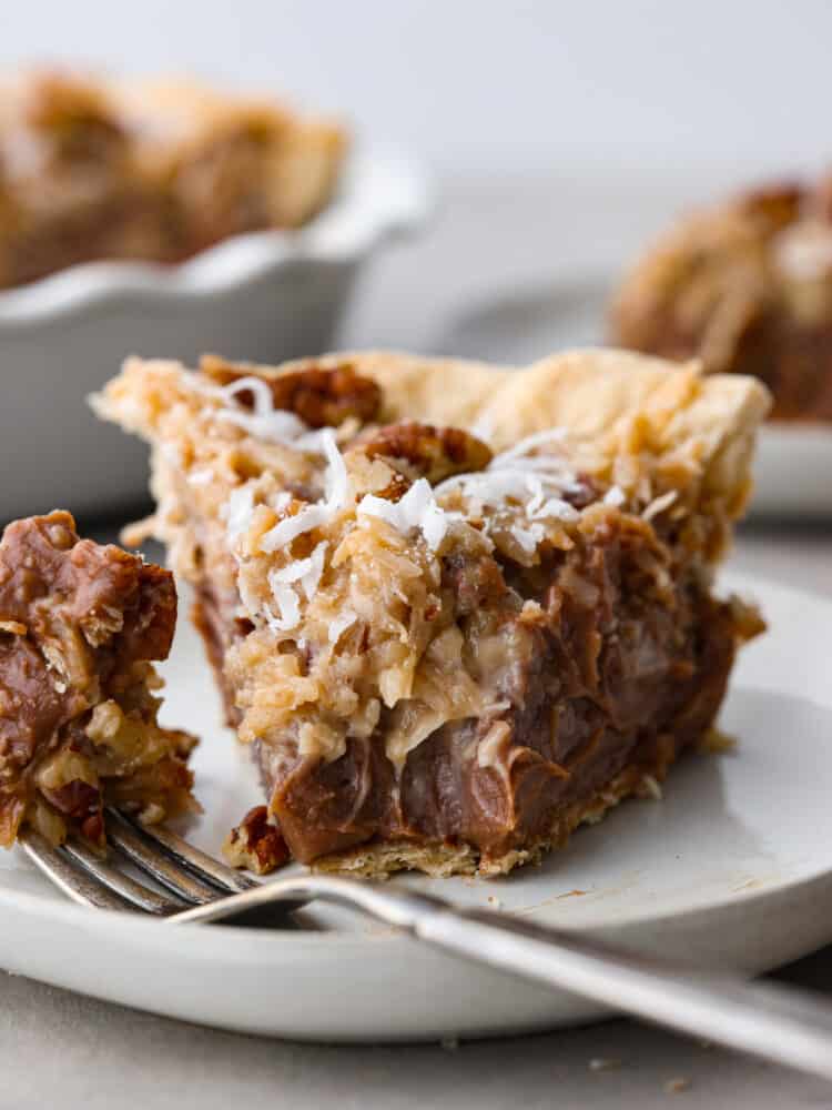 Closeup of a slice of German chocolate pie with a bite taken out of it.