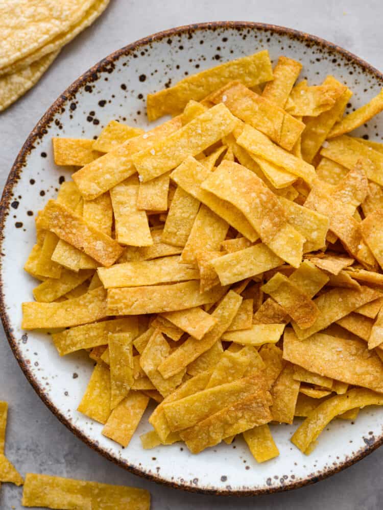 A close up of a plate filled with air fryer tortilla strips. 