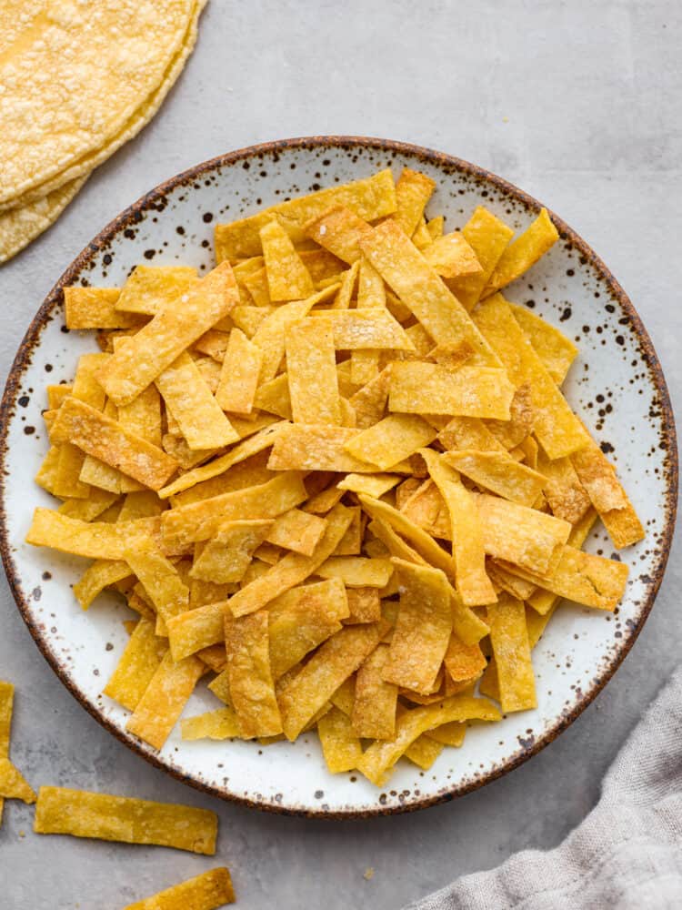 A plate with cooked tortilla strips. 