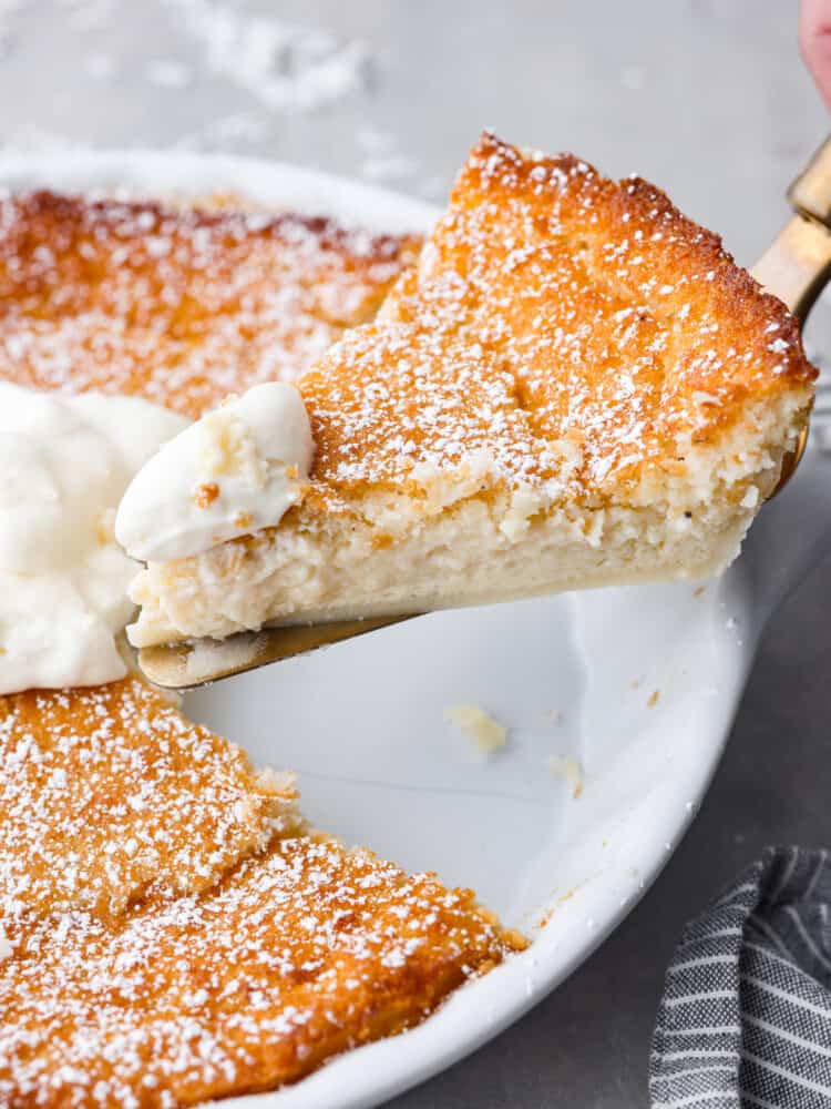 A slice of impossible pie being picked up with a metal cake spatula.