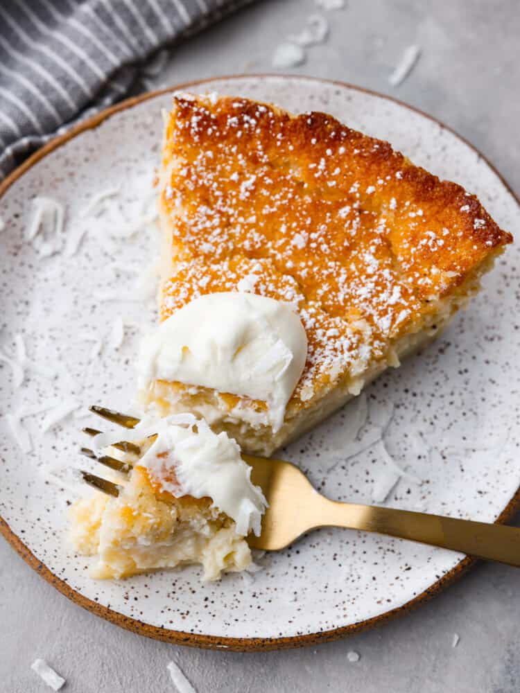 Closeup of a slice of pie. There is a small bite taken out of it with a gold metal fork.