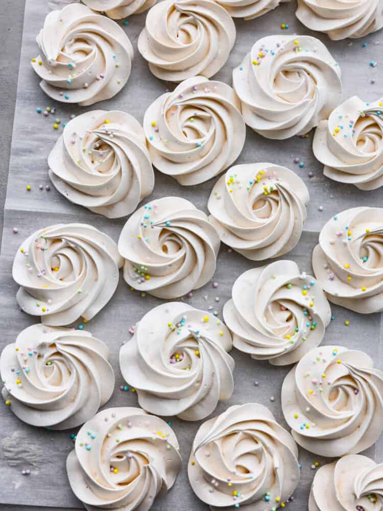 A zoomed out shot of the cookies on parchment paper with sprinkles.