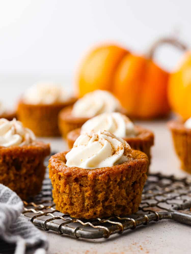 Closeup shot of a pumpkin pie cupcake on a wire cooling rack.