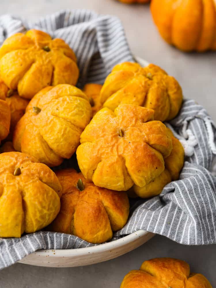 A basket of pumpkin dinner rolls. 