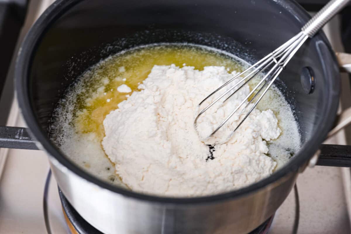 Overhead shot of melted butter with flour in a pot on the stove top. 