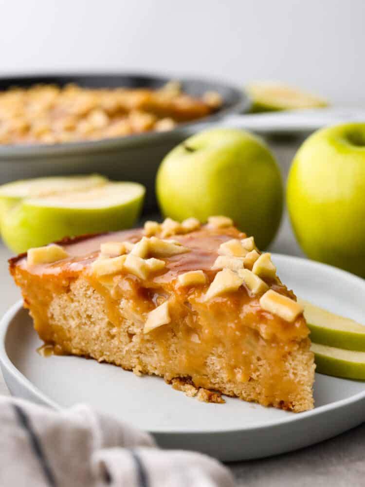 A slice of caramel apple skillet cake on a white plate.