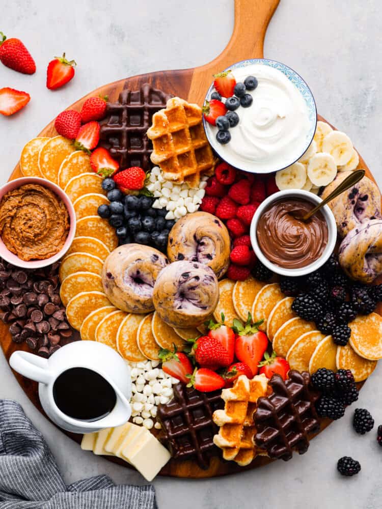 Overhead view of the breakfast charcuterie board with fruit scattered next to the board.