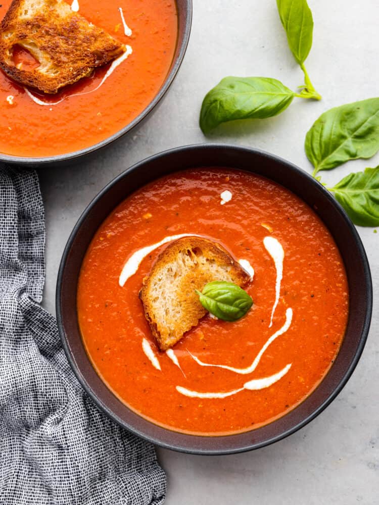 Two black bowls filled with soup.