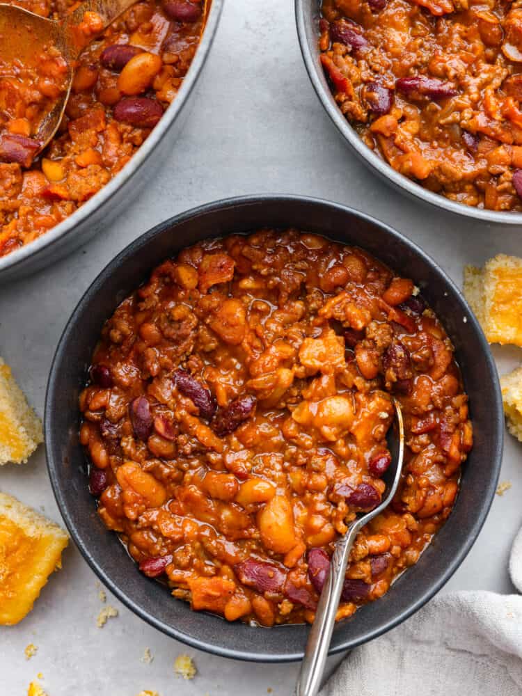 Top-down view of baked beans in a black serving bowl.