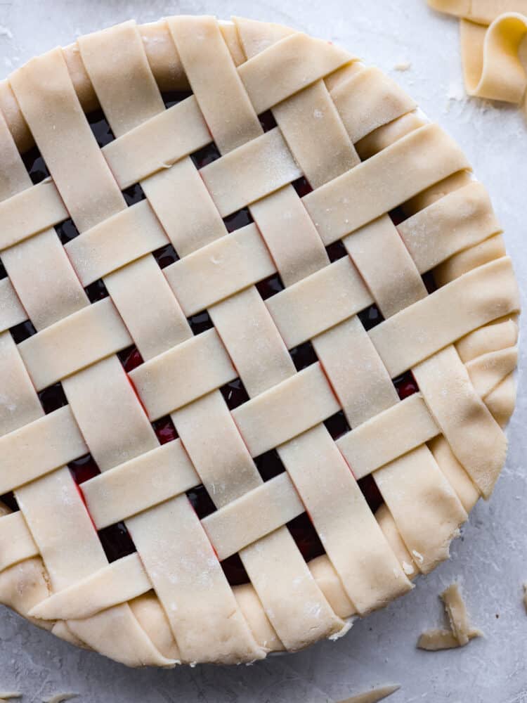 Lattice pie crust woven on top of a cherry pie.