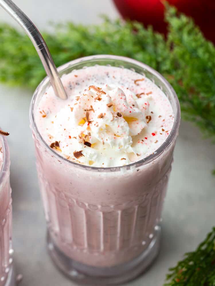 A peppermint milkshake in a glass cup.