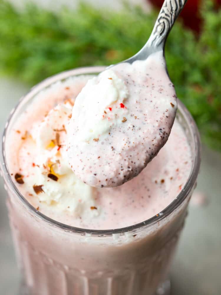 Closeup of a peppermint milkshake with a spoon scooping some out. 