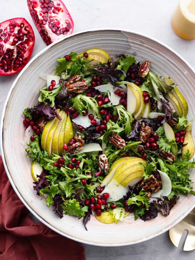 The top view of a pomegranate salad in a white bowl. 