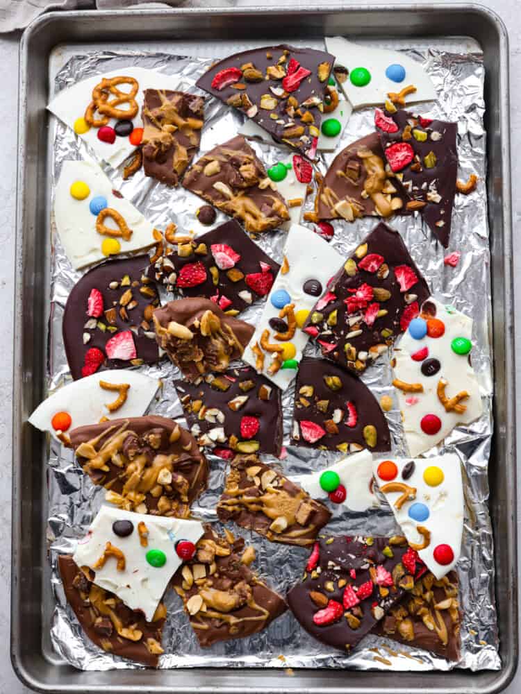 The topview of chocolate bark broken up on a pan lined with foil. 