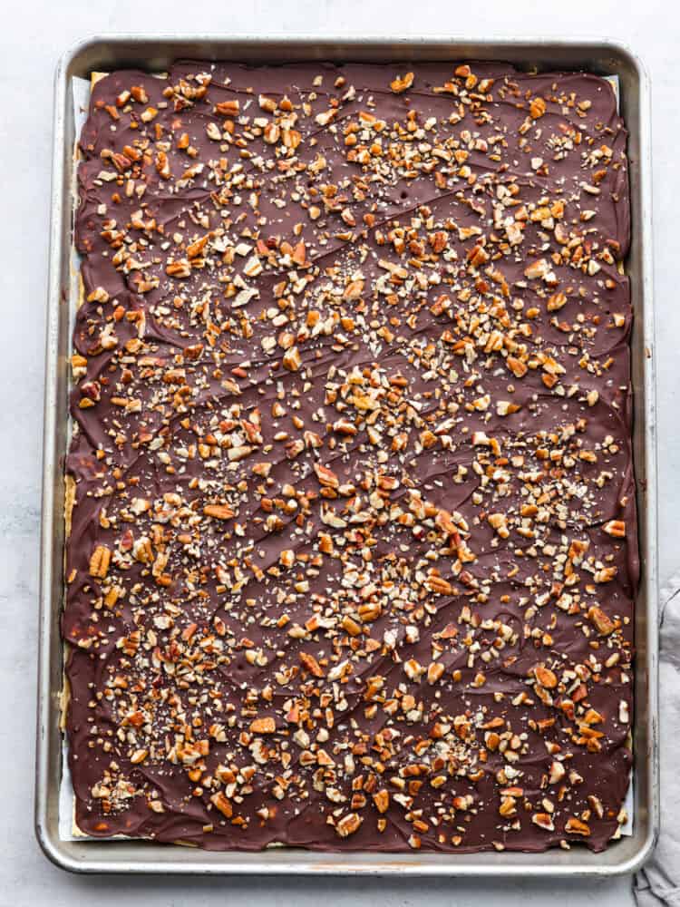 A finished pan of toffee with pecans sprinkled on top.