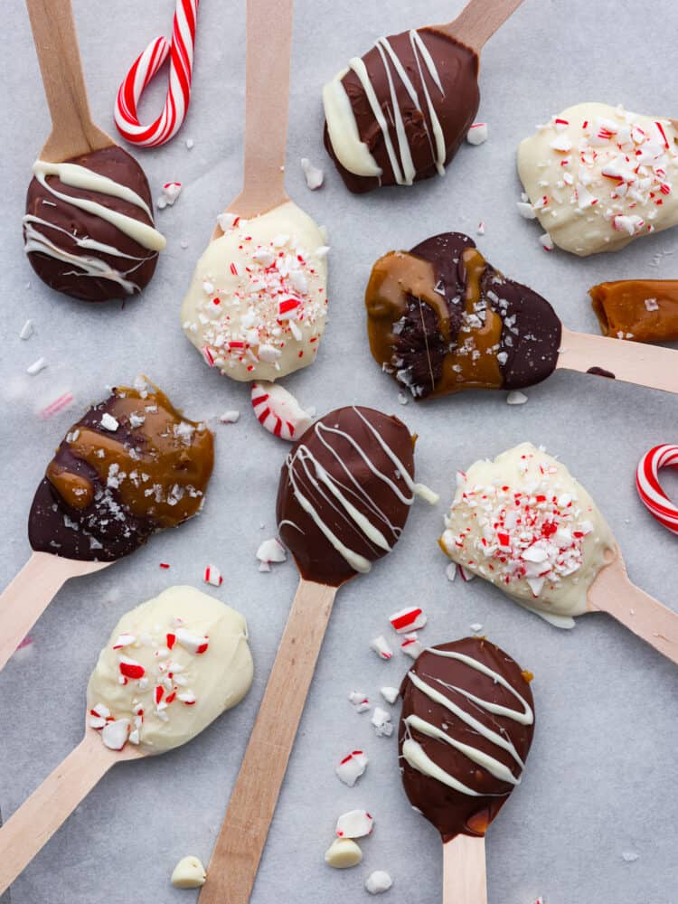 Various hot chocolate spoons laid out on parchment paper.