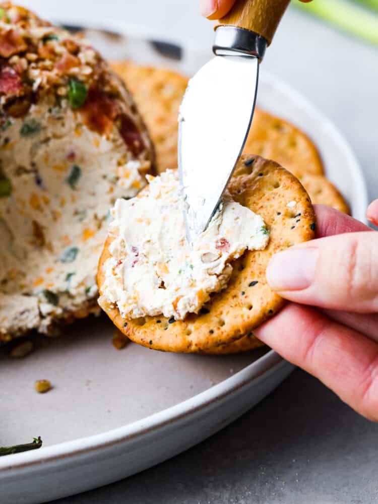 Spreading cheese onto a cracker.