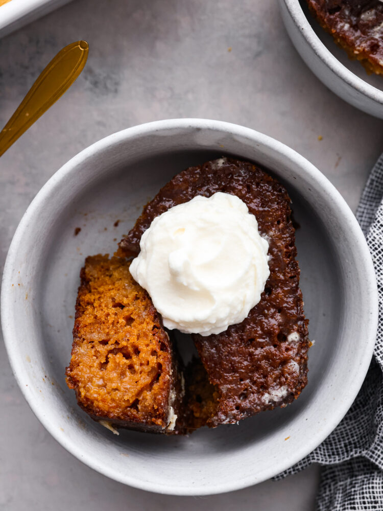 Closeup of malva pudding in a white bowl.