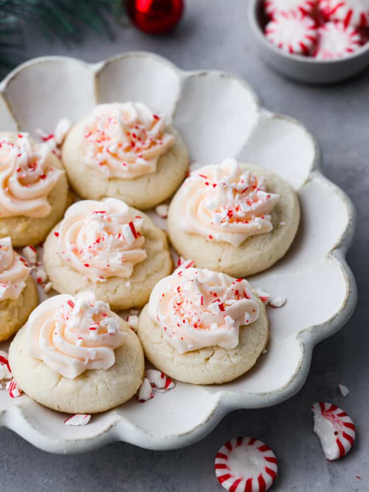 Peppermint beltways on a scalloped gray plate. Peppermint candies and ornaments surround the plate.