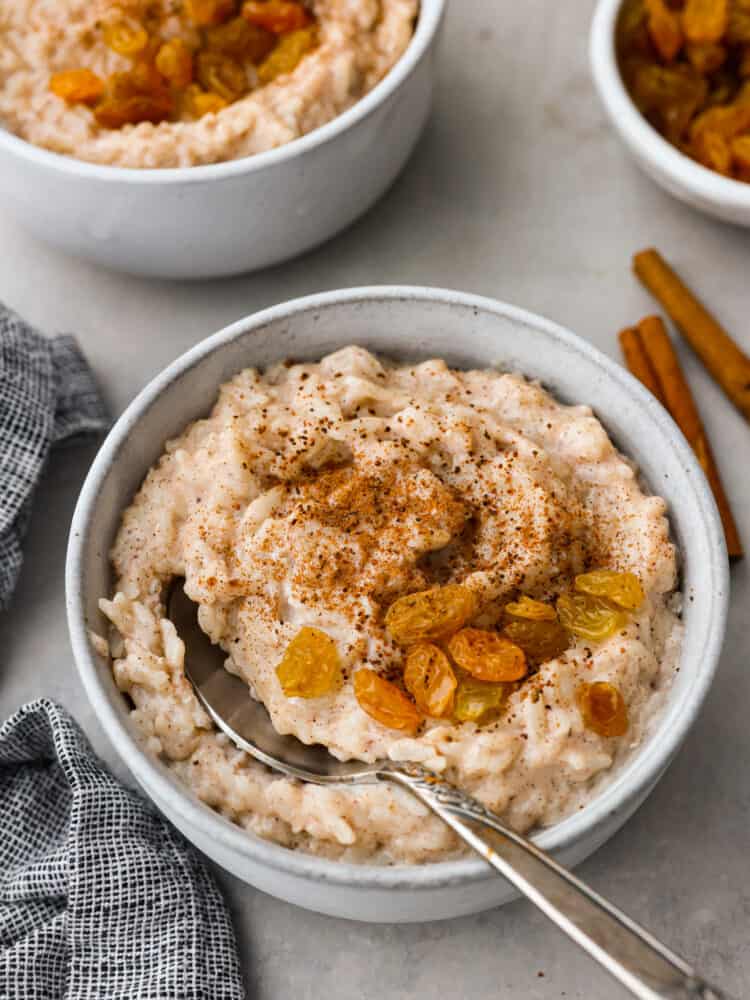 A bowl of rice pudding with a spoon in it.