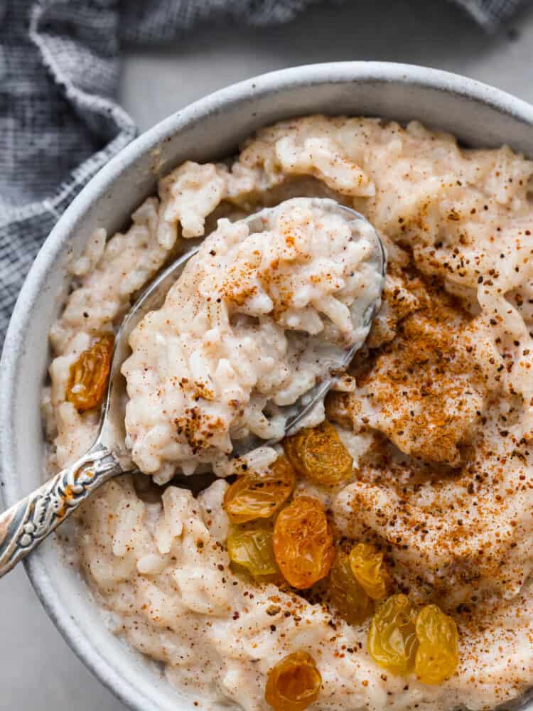 Closeup of rice pudding served with cinnamon, nutmeg, and raisins on top.