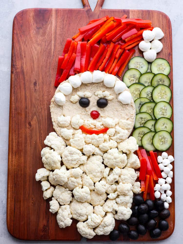 Santa's arms being made out of sliced red peppers and olives.