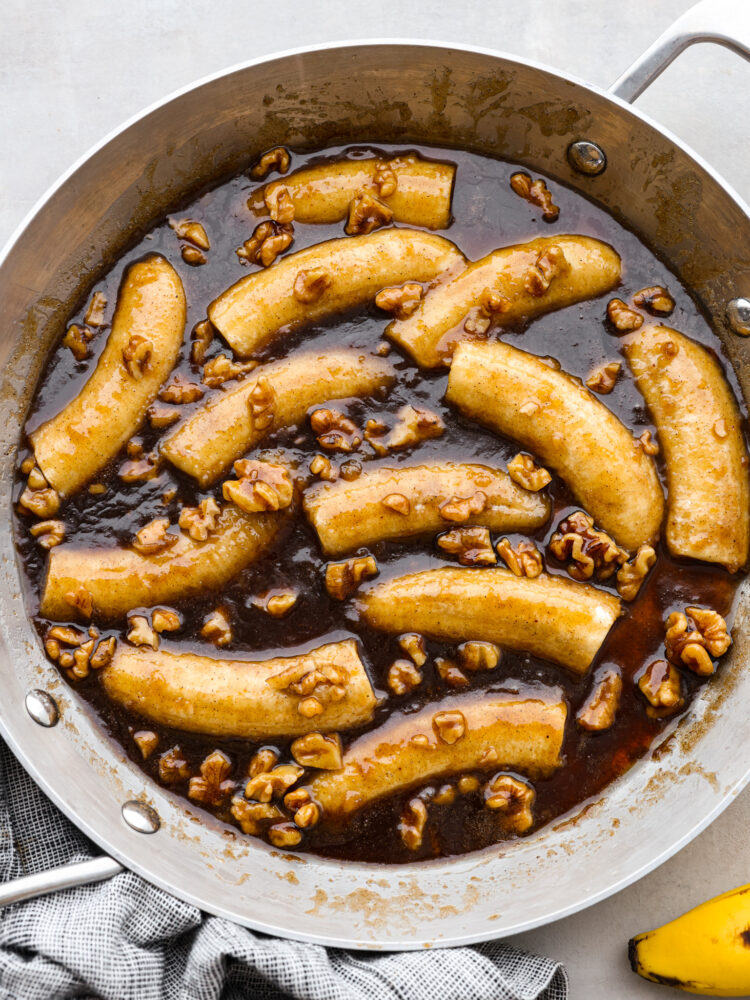 Top-down view of bananas foster in a metal skillet.