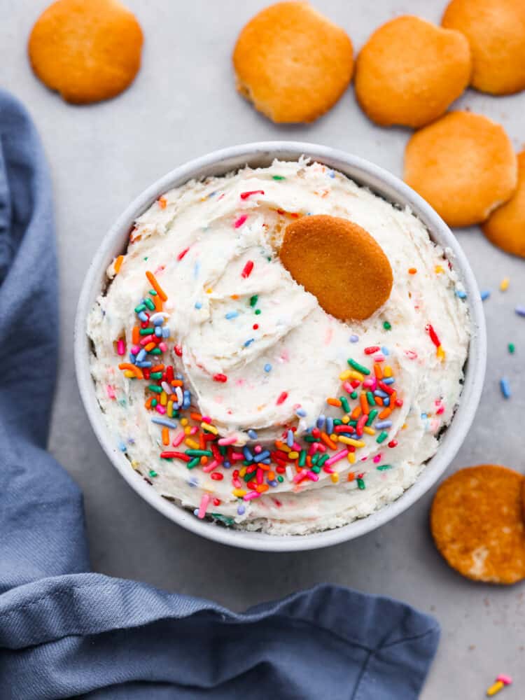 An overhead view of dunkaroo dip with sprinkles and nilla wafers.