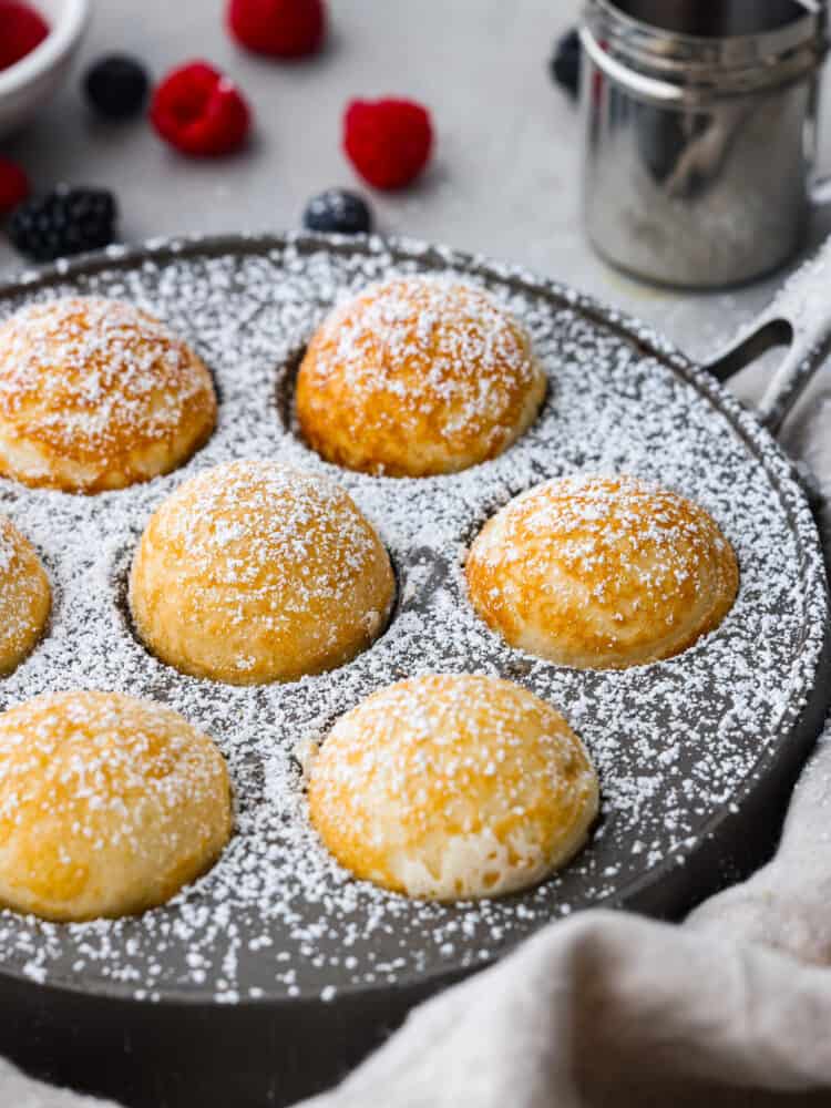 A side view of them in the pan with powdered sugar on top.