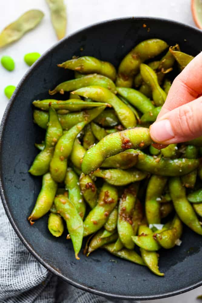 Picking up an edamame pod.