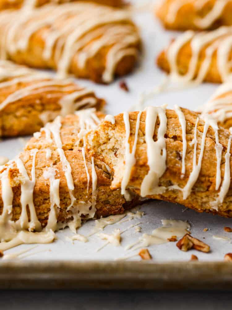 Maple pecan scones on a counter with a bite taken out of one.