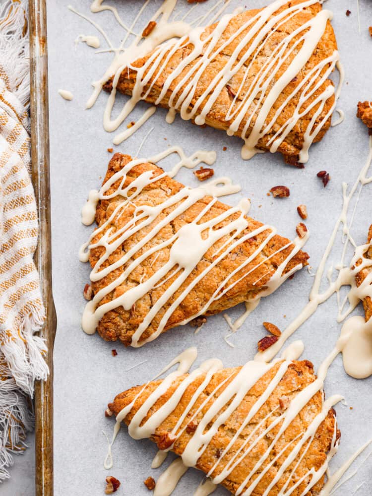 An overhead view of maple pecan scones with a maple drizzle.