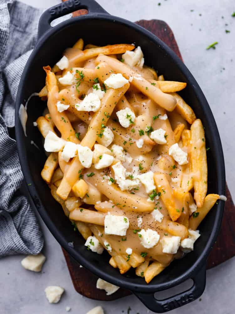 Poutine in a black dish.