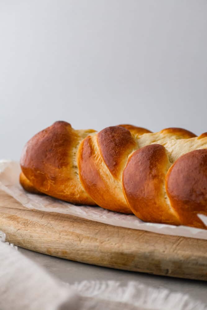 A brioche loaf sitting on parchment.