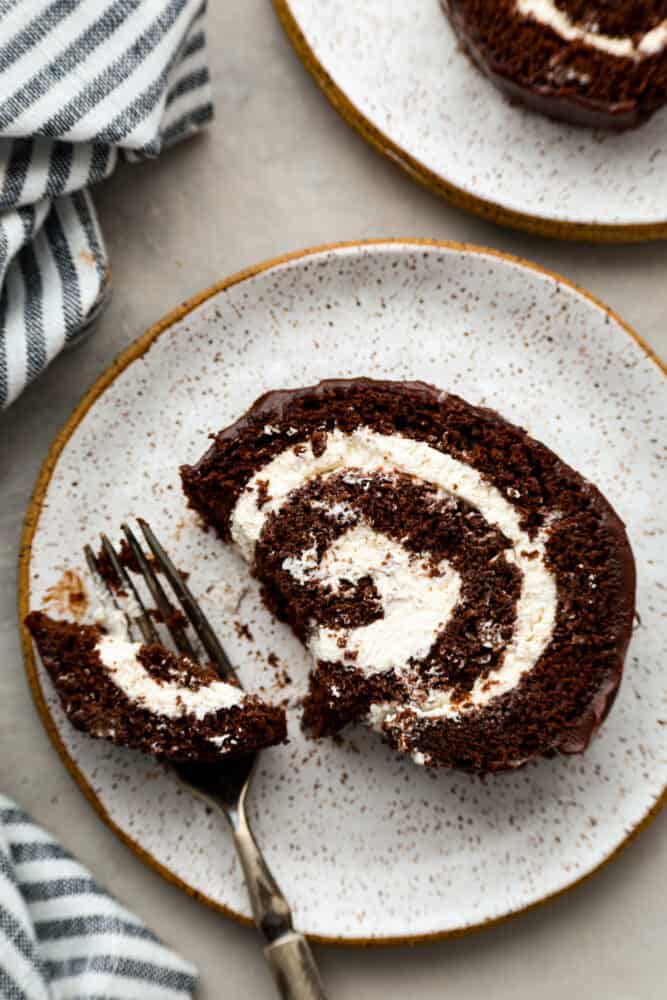 A piece of cake on the plate with a bite taken out of it.