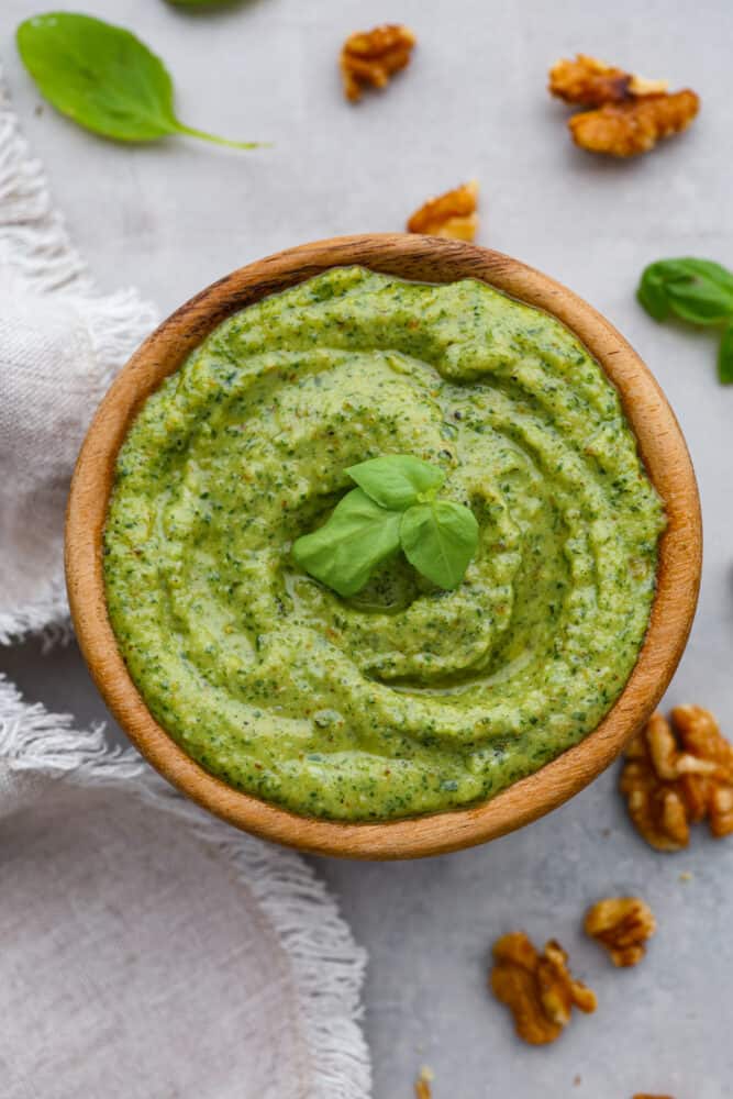 Top-down view of walnut pesto in a wooden bowl.