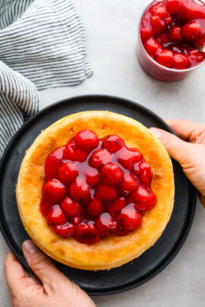 Top-down view of a whole cheesecake topped with fruit.